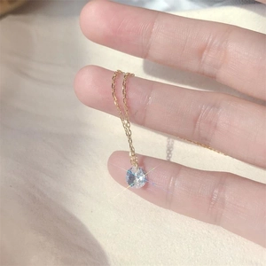 Minimalist S925 silver necklace with single zircon pendant held in hand for scale
