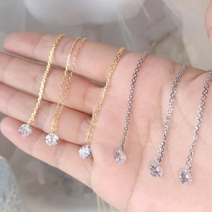 Close-up of minimalist S925 silver and gold necklace with sparkling round cubic zirconia