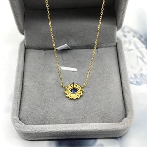 S925 silver necklace with sun-shaped evil eye pendant and blue stone on gray velvet