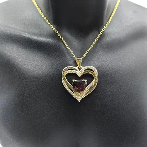 Détail du pendentif double cœur doré avec pierre rouge et gravure I Love You Forever