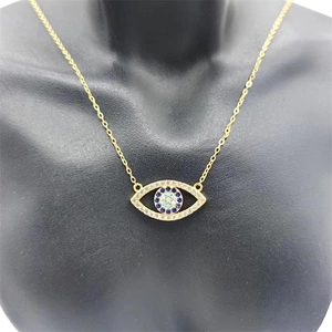 Gros plan du pendentif Mauvais Oeil en argent S925 avec zircons sur une chaîne dorée