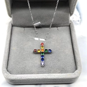 Close-up of rainbow cross pendant necklace featuring colorful cubic zirconia on silver chain