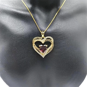 Détail du pendentif double cœur doré avec pierre violette et gravure I Love You