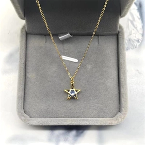 Detailed macro of S925 gold star pendant with blue zircon in a velvet jewelry box