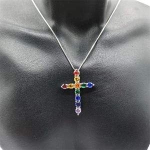 Macro shot of colorful zircon stones in a silver cross pendant on a black bust