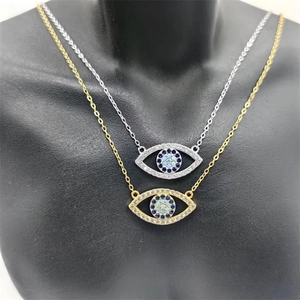 Détail des pendentifs œil maléfique en argent S925 dorés et argentés sur un mannequin