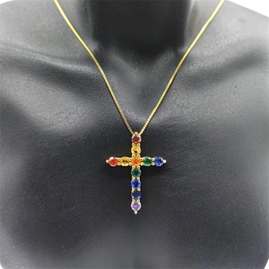 Detail of S925 silver cross pendant with rainbow colored gemstones on a gold chain