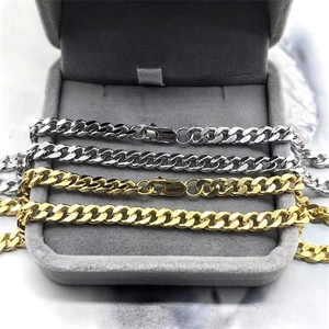 Close-up of gold and silver S925 sterling silver curb chains on a gray velvet jewelry box