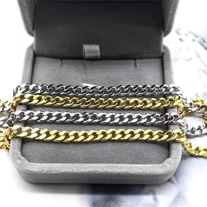 Detailed close-up of gold and silver S925 sterling silver Cuban link chains in a jewelry box