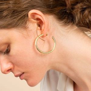 Boucles d'oreilles créoles en forme de C en argent S925 avec finition dorée sur modèle