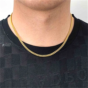 Close-up of golden Cuban link chain necklace on male model wearing a black shirt