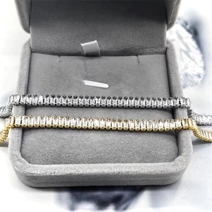 Dettaglio di bracciali tennis in oro e argento con zirconi rettangolari in una scatola