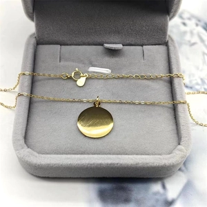 Détail macro du collier avec pendentif disque rond en argent S925 doré dans un coffret