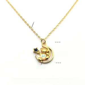 Detail view of gold-plated bear pendant with opal stone on a delicate silver chain