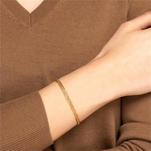 Gros plan d'un bracelet gourmette en argent S925 plaqué or porté au poignet