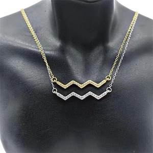 Detailed macro view of S925 sterling silver heartbeat necklaces in gold and silver finishes