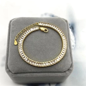 Dettaglio macro del bracciale tennis dorato con zirconi rettangolari e chiusura in argento S925