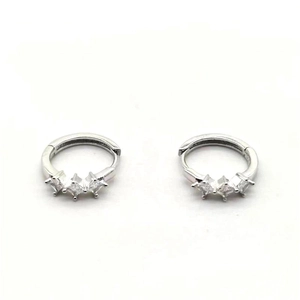 Macro detail of silver huggie hoop earrings with three square-cut clear zircon stones