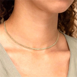 Close-up of a slim gold S925 sterling silver Cuban link necklace on a female model