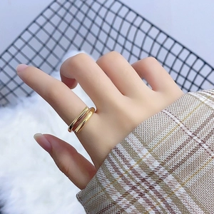 Detailed macro view of minimalist double-layer gold open ring worn on a finger