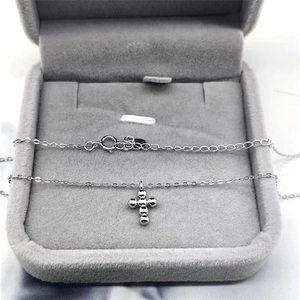 Detail of S925 sterling silver cross pendant featuring polished beads and lobster clasp