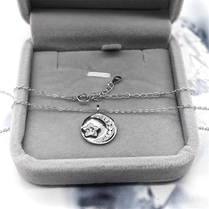 Detailed close-up of S925 sterling silver moon and star pendant on gray velvet box