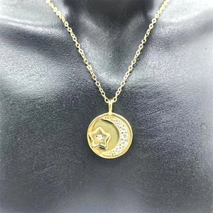 Detail view of a gold moon and star pendant necklace on a jewelry display mannequin