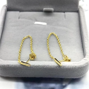 Macro detail of gold-plated S925 sterling silver chain drop earrings in a grey jewelry box