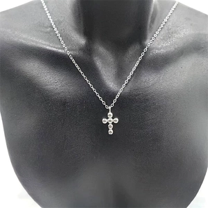 Detail of S925 sterling silver cross pendant featuring polished small beaded spheres