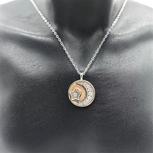 Macro detail of S925 sterling silver star and moon necklace on black mannequin