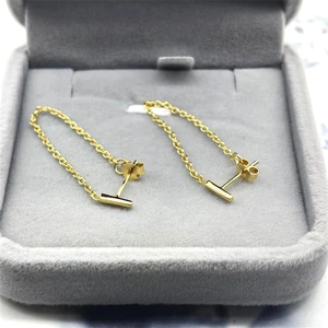 Macro view of minimalist S925 sterling silver gold bar chain earrings in jewelry box
