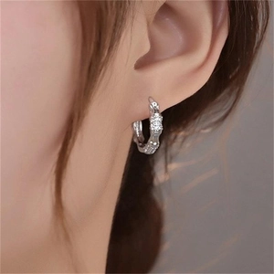 Gros plan de boucles d'oreilles créoles bambou en argent S925 avec diamants sur un modèle