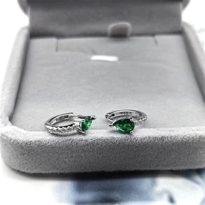 Vue macro des boucles d'oreilles goutte d'argent avec gemmes vertes et zircons