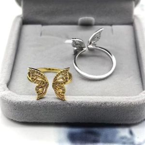 Detailed macro of gold and silver butterfly rings with sparkling cubic zirconia on velvet