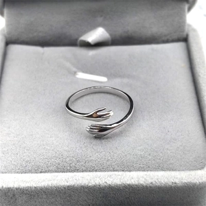 Minimalist S925 sterling silver hugging hands open ring in a grey jewelry box