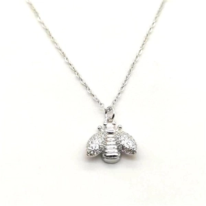 Macro shot of silver bee pendant showing granular texture and detailed insect design