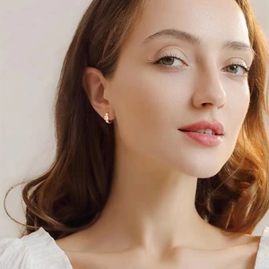 Close-up of elegant gold S925 silver geometric zircon hoop earrings worn by a model