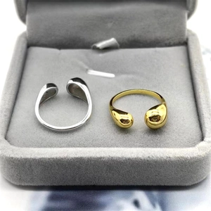 Macro shot of gold and silver asymmetrical water drop rings in a dark velvet jewelry box