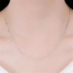 Macro detail of a sparkling S925 sterling silver lip chain necklace on female neck