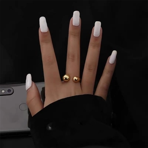 Close-up of a minimalist gold teardrop open ring on a model with black background