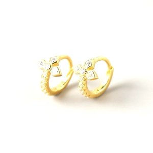 Detailed close-up of gold-plated cross hoop earrings set with shimmering cubic zirconia