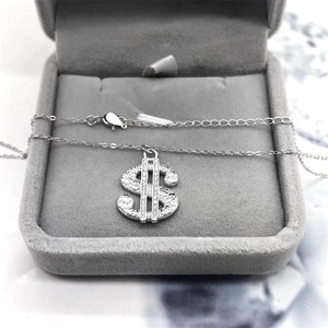 Detailed view of S925 sterling silver dollar sign pendant with zircon stones in a jewelry box