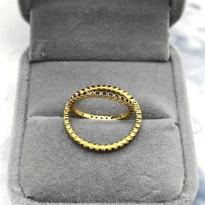 Makroaufnahme des vergoldeten Eternity-Rings mit blauen Zirkonia und Zahnrad-Details