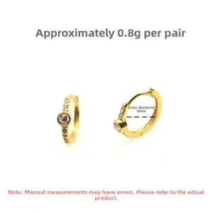 Gros plan de boucles d'oreilles créoles dorées avec zircons, poids 0,8g et taille 8mm