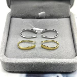 Macro view of minimalist S925 sterling silver U-shaped earrings in gold and silver finish
