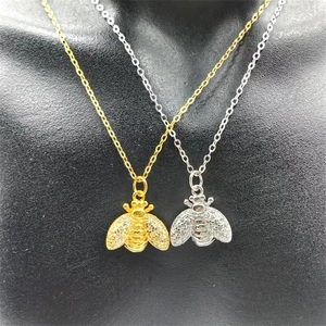 Detail of bee pendant necklaces in gold and silver finish with sparkling zircons