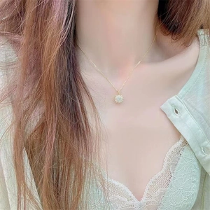 Elegante gouden zonnebloem ketting met sprankelende kristallen gedragen door een vrouw op ketting
