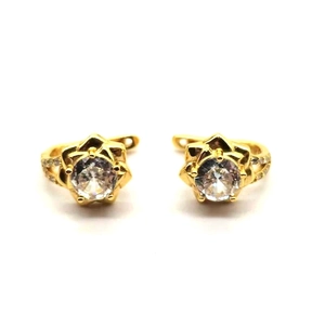 Primo piano di orecchini a camelia dorati con grande zircone e petali di strass
