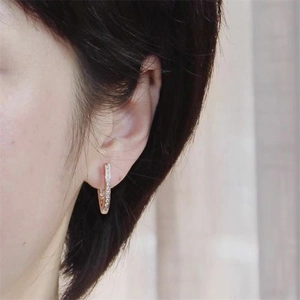 Close-up of rose gold S925 sterling silver ear cuffs with pavé-set zircons on ear