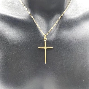 Polished gold cross pendant necklace displayed on a mannequin for jewelry sizing